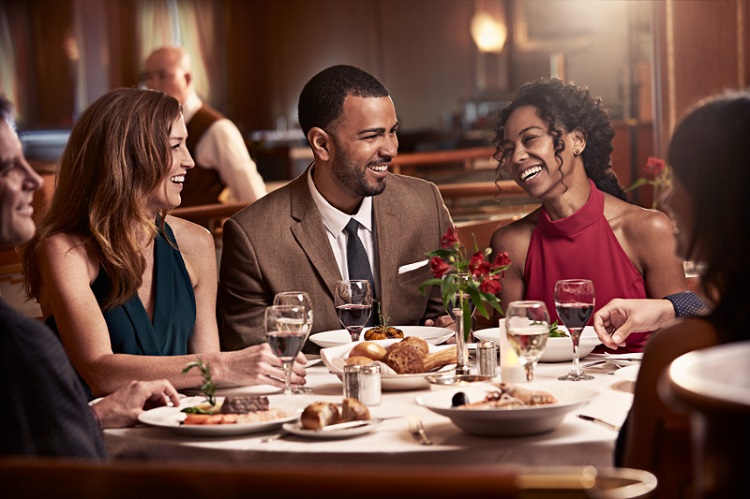 Well-dressed friends enjoying dinner in the main dining on-board Princess Cruises