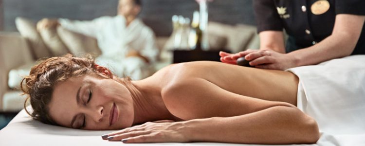 Lady enjoying a hot stone massage in the Lotus Spa on Royal Princess