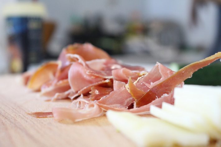 Jamon Serrano and artisan cheese on a wooden chopping board