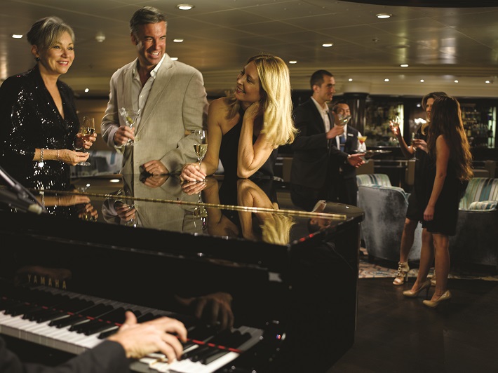 Passengers on a cruise ship enjoying a black tie evening in a piano bar