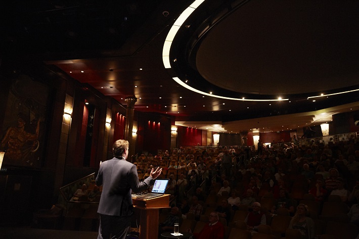 A speaker giving a lecture in Cunard's on-board theatre