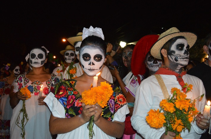 People wearing sugar skull makeup taking part in a Day of the Dead parade