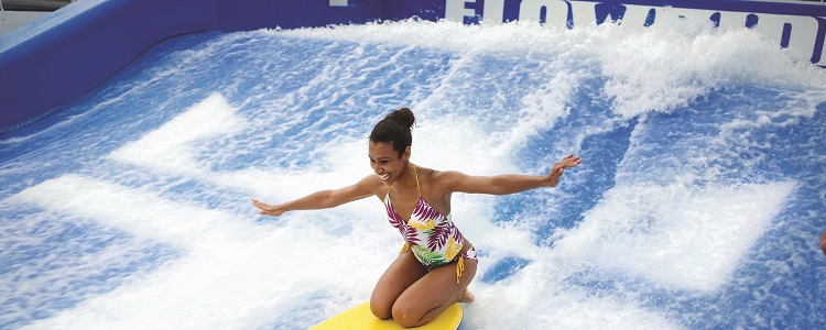 Woman using the Flowrider surf simulator on-board Independence of the Seas