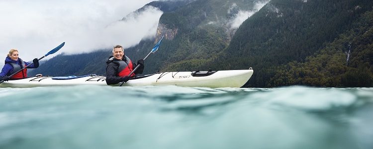 A couple kayaking on choppy water in Alaska