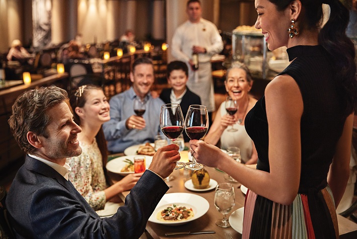 A multi-generational family toasting their voyage in a restaurant on-board a Princess Cruises ship