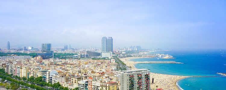 Panorama of Barcelona beach and skyscrapers sitting under a blue sky