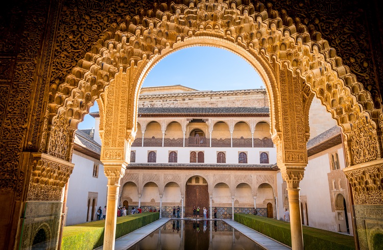 An ornate archway leading to picturesque gardens at the Alhambra Palace in Granada cruise port