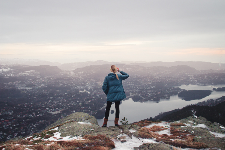 A solo cruise passenger admiring the view from a mountain in Bergen