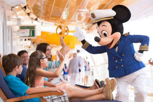 Captain Mickey Mouse high-fiving a family on a Disney Cruise Line ship