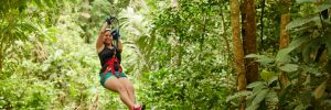 A woman on a zip line excursion through the rainforest on a Princess cruise