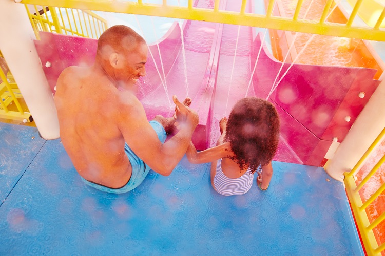 A father and daughter waiting to go down the slides in the Carnival Panorama WaterWorks